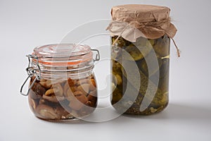 Jars of Homemade pickled vegetables: cucumbers, pickled honey agarics mushrooms.