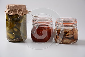 Jars of Homemade pickled vegetables: cucumbers, pickled honey agarics mushrooms.