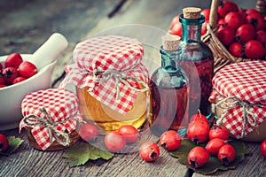 Jars of honey, tincture bottles and mortar of hawthorn berries photo