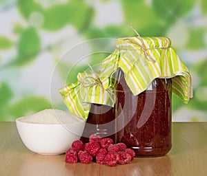 Jars of jam and handful raspberries