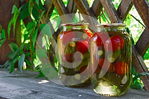 jars of pickled assorted tomatoes and cucumbers on the table