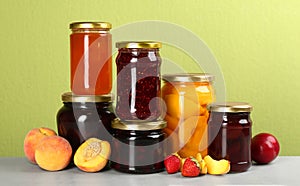 Jars of pickled fruits and jams on light table