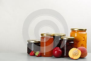 Jars of pickled fruits and jams on table. Space for text