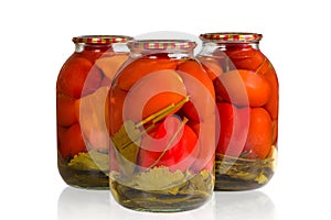 Jars of pickled tomatoes on a white background