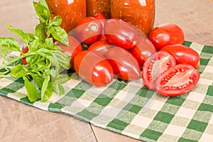 Jars of sauce with paste tomatoes and basil