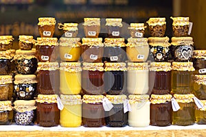 Jars with sweet natural honey on a shelf in a store. Sale of natural honey . Sale of honey, beeswax and bee products.