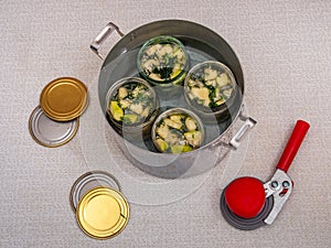 Jars of vegetables in a large aluminum pan. pasteurization of canned vegetables