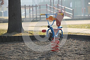 Jaslo, Poland - 9 2 2019: Swing in the form of a bike on a spring. Playground equipment. Multicolored wooden toys for children and