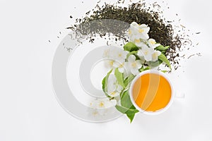 Jasmine dry green tea leaves with fresh jasmine flowers and cup of tea on white background.