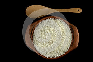 Jasmine rice in a clay pot and the wood ladle on white background