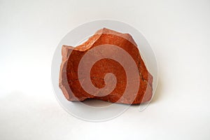 Macro shooting raw red jasper stone rock on white background. photo