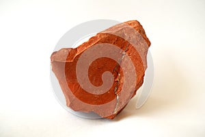 Macro shooting raw red jasper stone rock on white background. photo