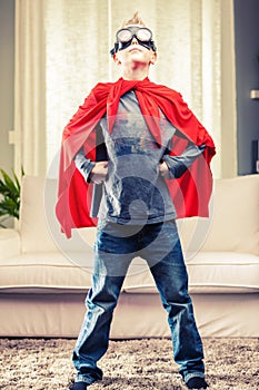 Jaunty proud young Super Hero posing in a red cape