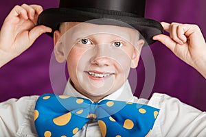 Jaunty young boy in a bow-tie and top hat photo