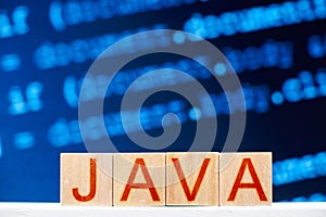 java concept. wooden blocks with java inscription and program code on the background.