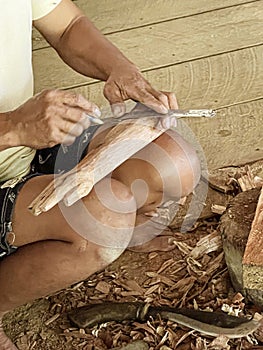 Java, Indonesia, June 13, 2022 - Man carves Tau Tau which are wooden effigies carved in Toraja to represent people who