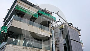 Java, Jakarta, Indonesia, May 20, 2022. Workers are using gondola as vertical trasport to install aluminum composite on the photo