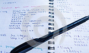 Translations of calculus systems on a notebook and black pen. creation of computer programs. work of the programmer and system