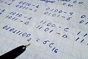Translations of calculus systems on a notebook and black pen. creation of computer programs. work of the programmer and system