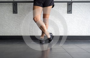 Jazz dancer posing at the barre with jazz shoes on