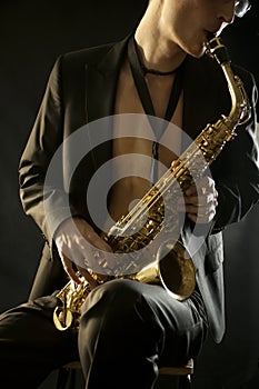 Jazz man plaing a saxophone on black