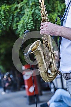 Jazz musician playing the saxophone on the street of European city
