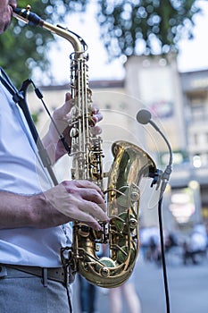 Jazz musician playing the saxophone on the street of European city. A street musician plays the saxophone