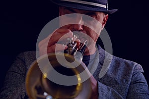 A jazz musician plays a silver trumpet