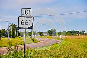 JCT 661 sign next to highway in summer with blue sky and thin clouds