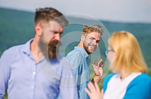 Jealous concept. Man with beard jealous aggressive because girlfriend interested in handsome passerby. Passerby smiling