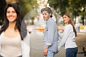 Jealous Girlfriend Calling Boyfriend Distracted By Other Attractive Woman photo