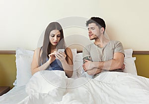 Jealous husband watching wife mobile phone on the bed