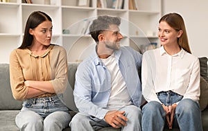 Jealous Lady Looking At Flirting Couple Sitting Together At Home