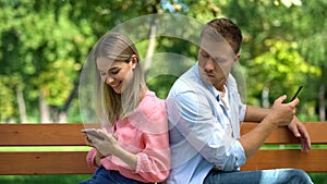 Jealous man checking girlfriend phone reading messages, couple distrust conflict