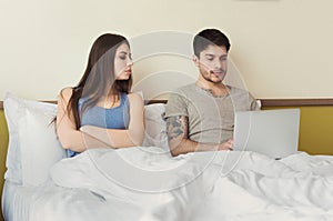 Jealous wife looking on laptop while husband typing