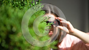 Jealous woman with binoculars hiding behind tree spying for husband, betrayal