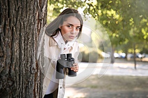 Jealous woman with binoculars spying on ex boyfriend in park