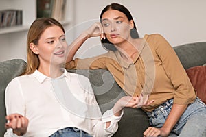 Jealous Woman Listening With Envy To Her Friend Bragging Indoors