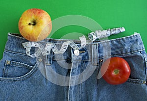 Jeans, centimeter tape, tomato and apple