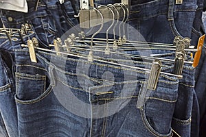 Jeans on hanger, store background. Retail trade in consumer goods. Abstract background