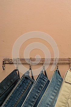 Jeans hanging on the back of a door with a copy space