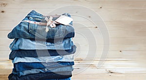 Jeans with measure and tag label stacked on a wooden