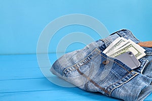 Jeans with money and smartphone in a back pocket.