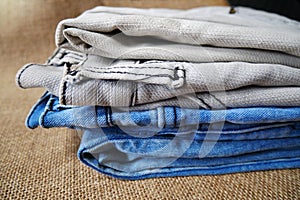 Jeans trousers stack on white background.