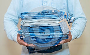 Jeans trousers stack on white background.