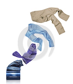 Jeans unfolds and fly out of the pile with pants on white