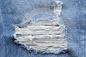 Jeans in wash blue with rip. Denim background, texture. Ripped d