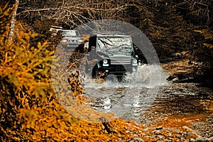 Jeep crashed into a puddle and picked up a spray of dirt. Mud and water splash in off-road racing. Off the road travel