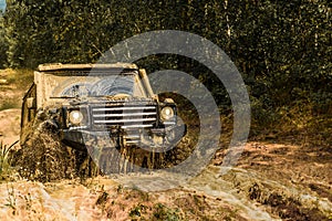 Jeep crashed into a puddle and picked up a spray of dirt. Off road sport truck between mountains landscape. Track on mud