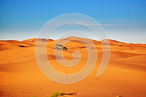 Jeep in sand dunes in the Sahara Desert, Morocco